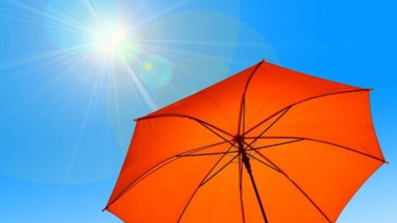 太陽が輝く青空の下、日傘が広がる暑熱順化のメリットと実践方法を伝えるアイキャッチ。熱中症対策の重要性を強調しています。