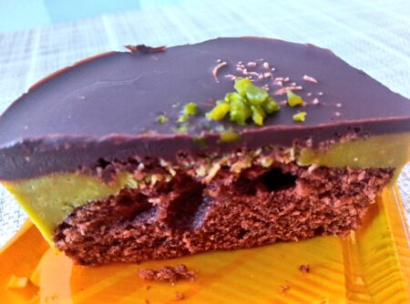 カットされた断面です。一番上には厚みのあるチョコレート、その下にはピスタチオクリームの層、そして一番下にはスポンジケーキが見えます。緑色の層には、細麺状小麦生地の「カダイフ」が確認できます。