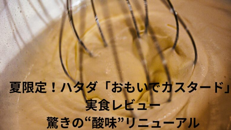 泡立て器で混ぜられている、白っぽい黄色をしたカスタードクリームをクローズアップで捉えたものです。クリームには細かな気泡が含まれており、滑らかな質感が伝わってきます。泡立て器の金属製のワイヤーがクリームの中に深く差し込まれ、動きのある様子が伺えます。画像の下部には「夏限定！ハタダ『おもいでカスタード』実食レビュー 驚きの“酸味”リニューアル」というテキストが黒字で重ねられています。これは、ハタダというメーカーの夏季限定スイーツ「おもいでカスタード」のレビュー記事のアイキャッチ画像として使用されることが想定され、特にリニューアルによって加えられた「酸味」が特徴として強調されていることが分かります。