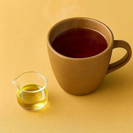 アガベシロップ入りホットルイボスティーを湯気の立つ茶色のカップに注ぎ、隣に黄金色のアガベシロップを入れた小さなガラスピッチャーを添えた夜のリラックスドリンク。血糖値を乱さず、穏やかな夜をサポート。