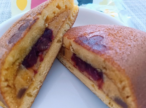 半分にカットされた「どら一 焼き芋カスタード」の断面。たっぷりの焼き芋カスタードクリームの中央に、つややかな粒あんが入っている様子。