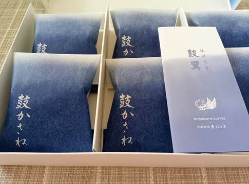 羽田空港限定「鼓かさね」の6個入りギフトボックス。空をイメージした青いグラデーションの個包装が整然と並ぶ。