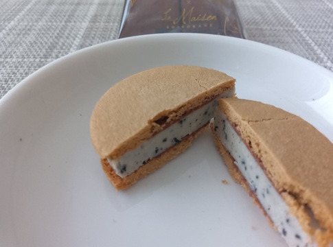 羽田空港限定「カフェショコラウィッチ」のカフェラテ味の断面。白いチョコレートの中に粗挽きコーヒー豆が見える。