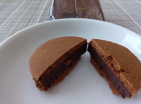 羽田空港限定「カフェショコラウィッチ」珈琲味の断面。ココア生地のクッキーと濃厚なビターショコラ。