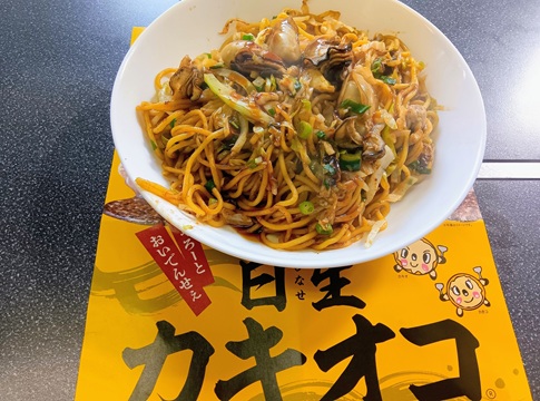 岡山備前市日生名物の牡蠣が入った焼きそば。大ぶりの牡蠣とキャベツ、ソースの絡んだ麺が白い皿に盛られている。