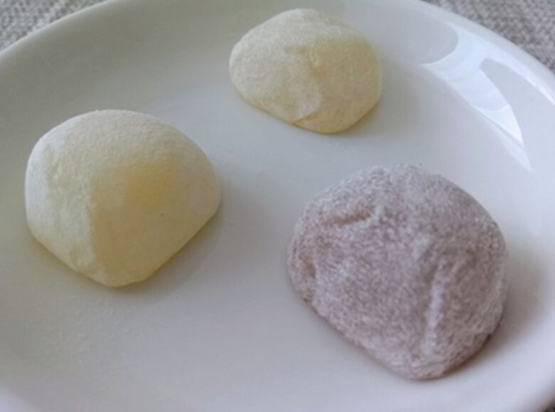 白いお皿に盛られた3色の廣榮堂きびだんご（元祖・海塩・黒糖）。表面はきめ細かくスベスベしており、丸く柔らかいお餅の質感。