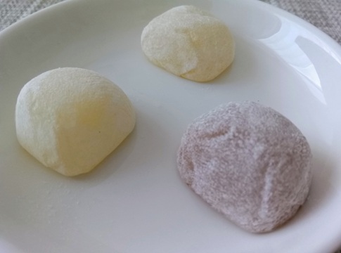 白いお皿に盛られた3色の廣榮堂きびだんご（元祖・海塩・黒糖）。表面はきめ細かくスベスベしており、丸く柔らかいお餅の質感。