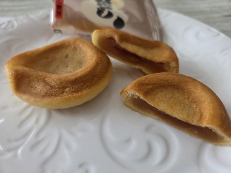 博ったらしみたらし饅頭。丸いフォルムと半分にかじった断面のみたらしタレ餡