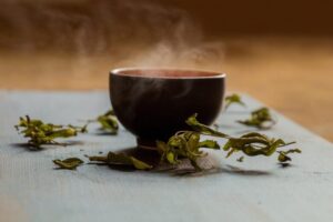 よもぎ茶と乾燥ハーブ葉・湯気の立つカップ｜更年期によもぎ茶・よもぎ蒸しの効果をアロマセラピストが解説